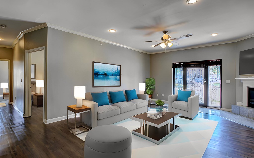 A modern living room with a white sofa, a coffee table, and a ceiling fan.