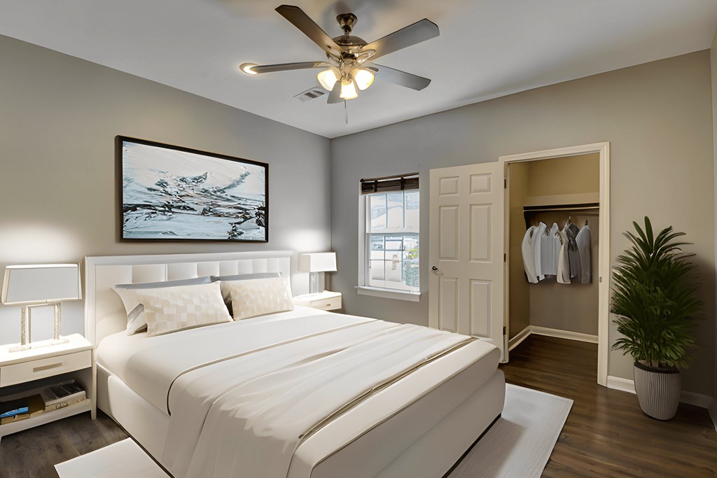 A bedroom with a large bed and a ceiling fan.