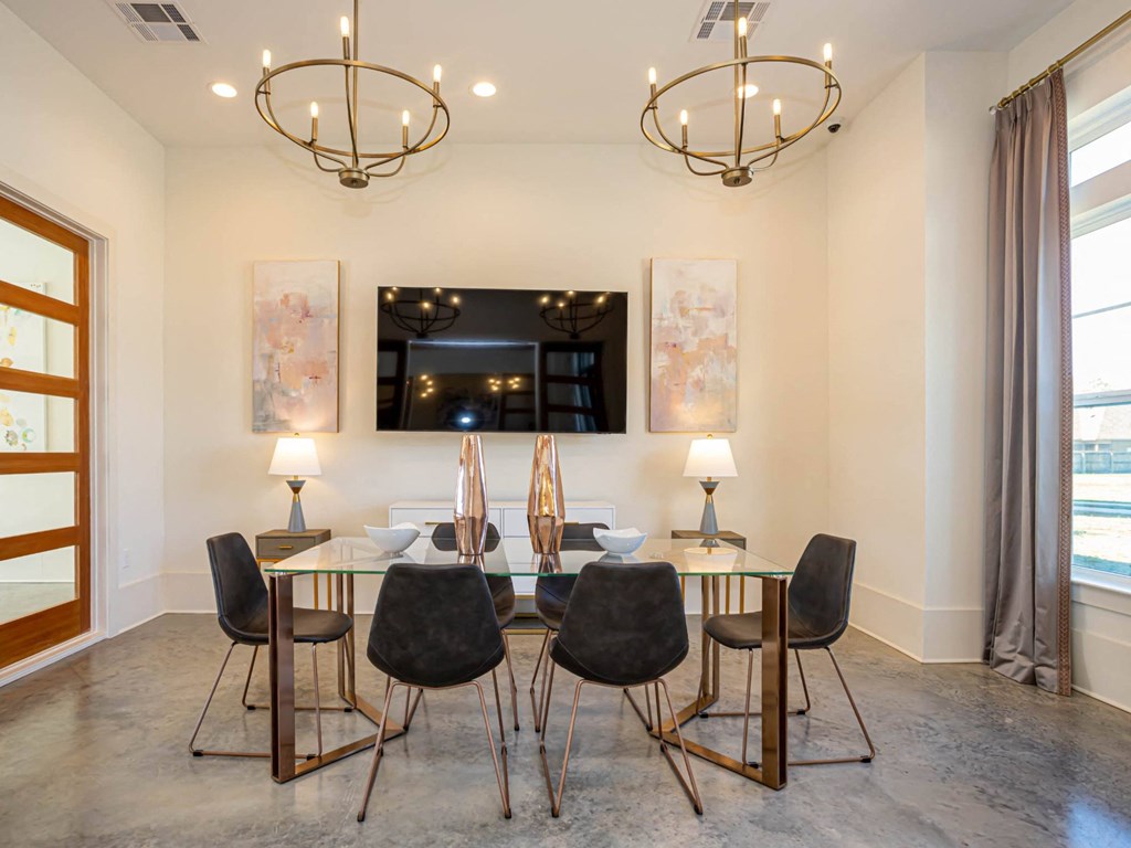 a dining room with a glass table and chairs