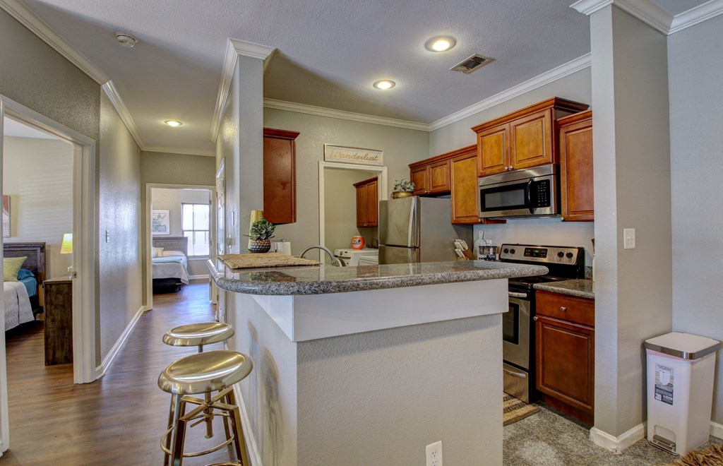 A kitchen with a white counter top and wooden cabinets.