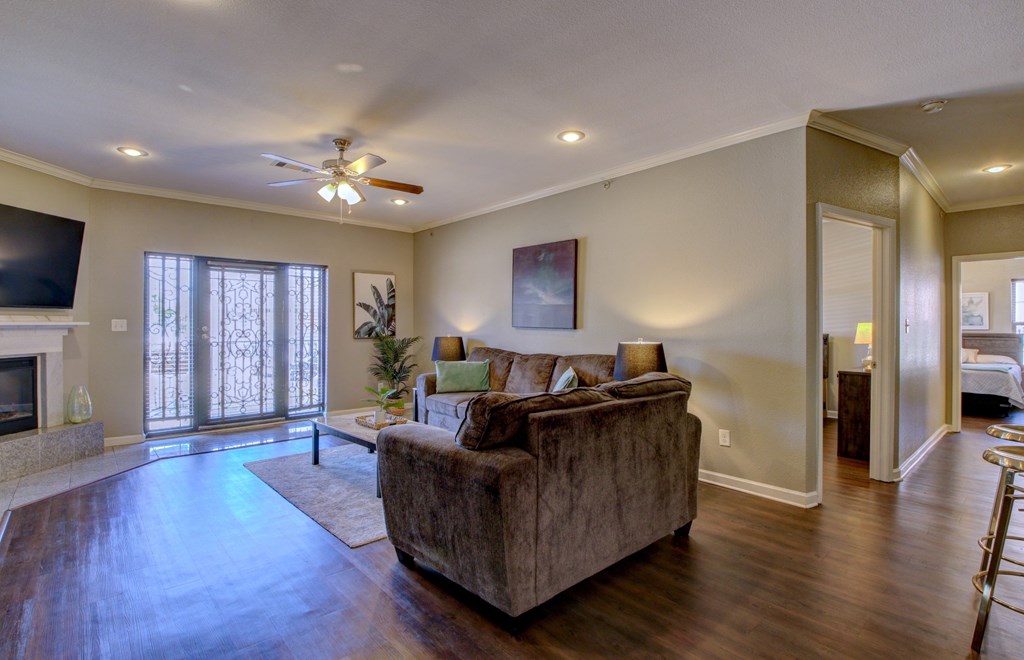 A living room with a couch, a fireplace, and a ceiling fan.