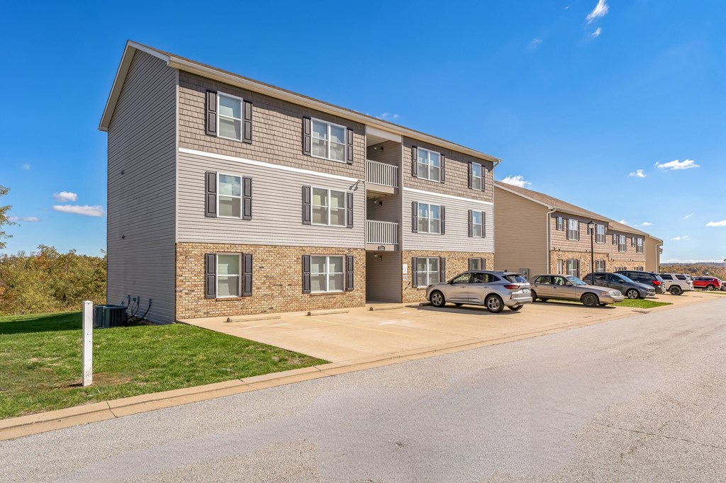 an apartment building with cars parked in front of it