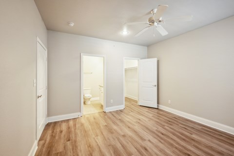 an empty living room with wood flooring and a ceiling fan