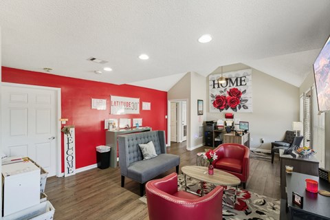 A living room with a red couch and a grey armchair.