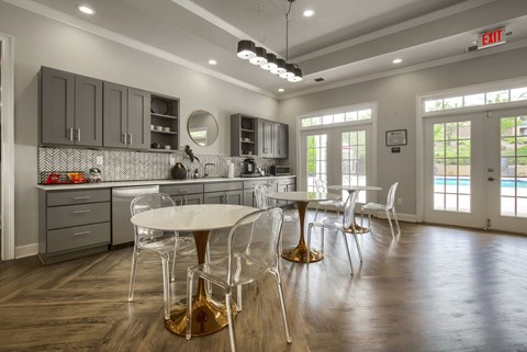 a kitchen with gray cabinets and a white table and chairs