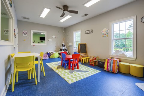 a childs play area with a table and chairs and a television
