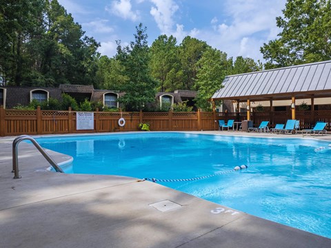 a swimming pool with chairs and a resort style pool