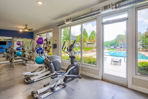 a home gym with a view of the pool