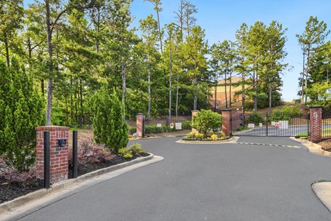 a large driveway with a brick fence and brick pillars