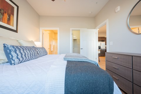 A bedroom with a large bed and a painting on the wall.