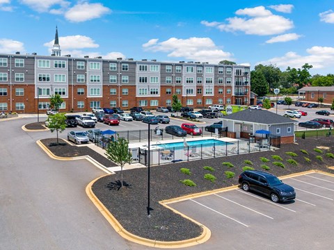 A parking lot with a pool and a building in the background.
