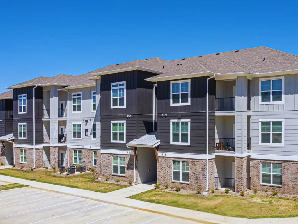 an apartment building on the side of a sidewalk