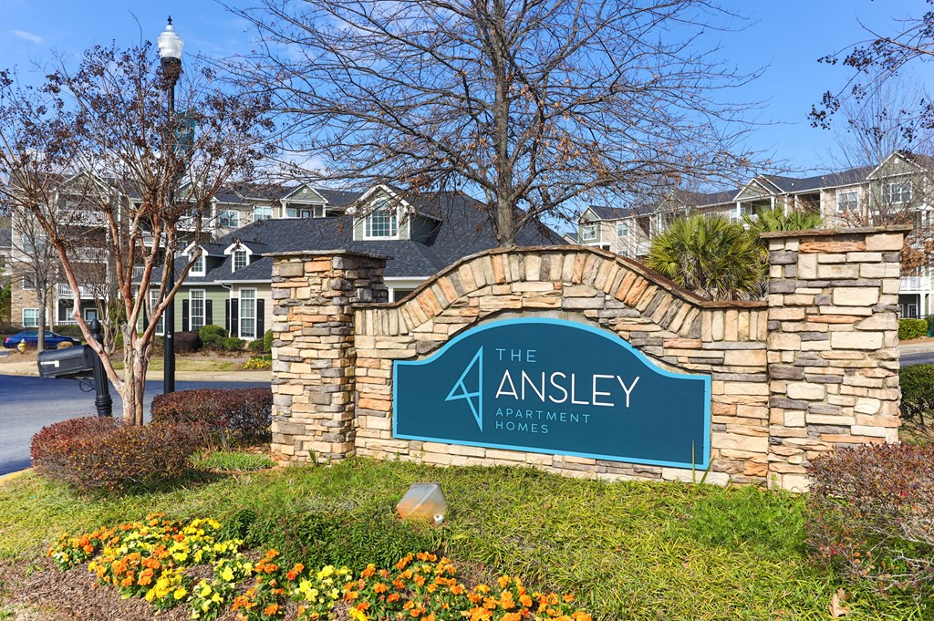 the apartments sign in front of a stone wall