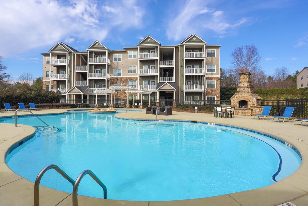 a large swimming pool with an apartment building in the background