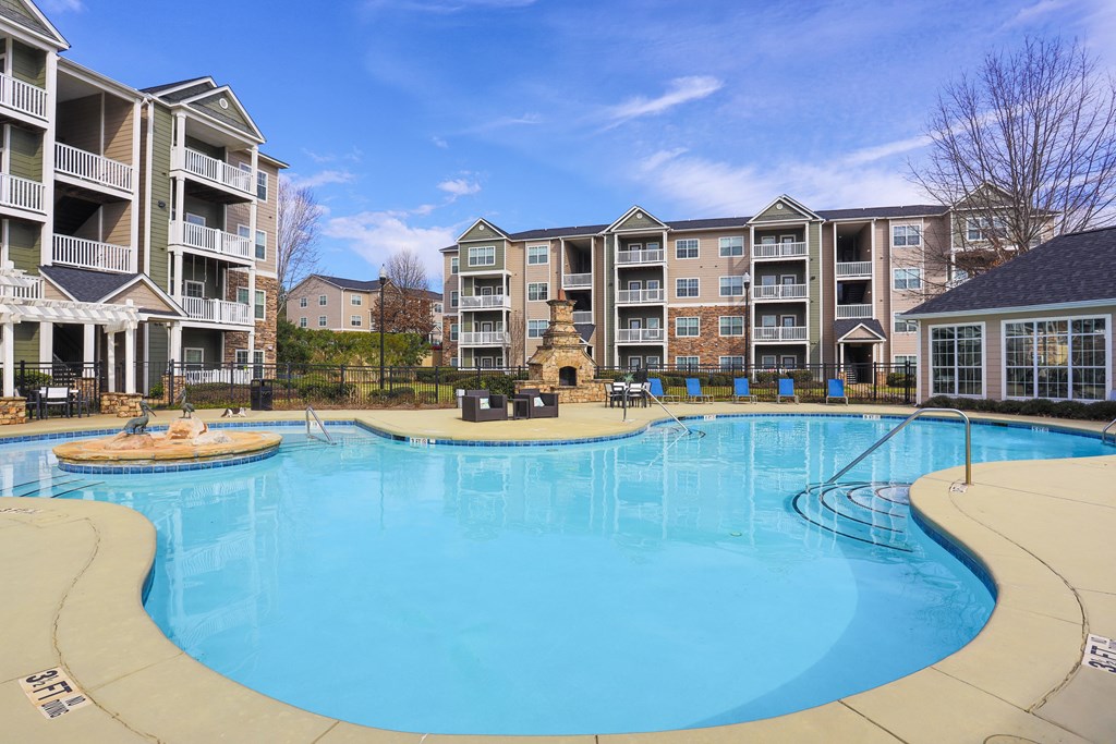 a large swimming pool with an apartment building in the background