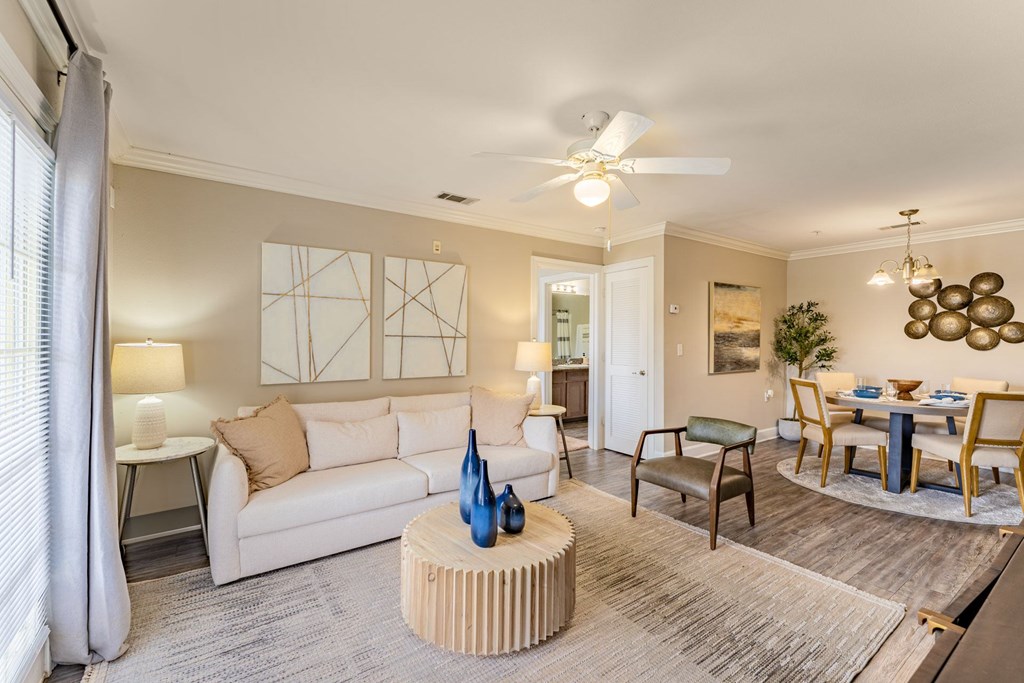 A living room with a white couch, a wooden coffee table, and a ceiling fan.