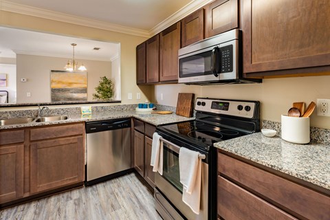 A kitchen with a black stove top oven and a black microwave above it.