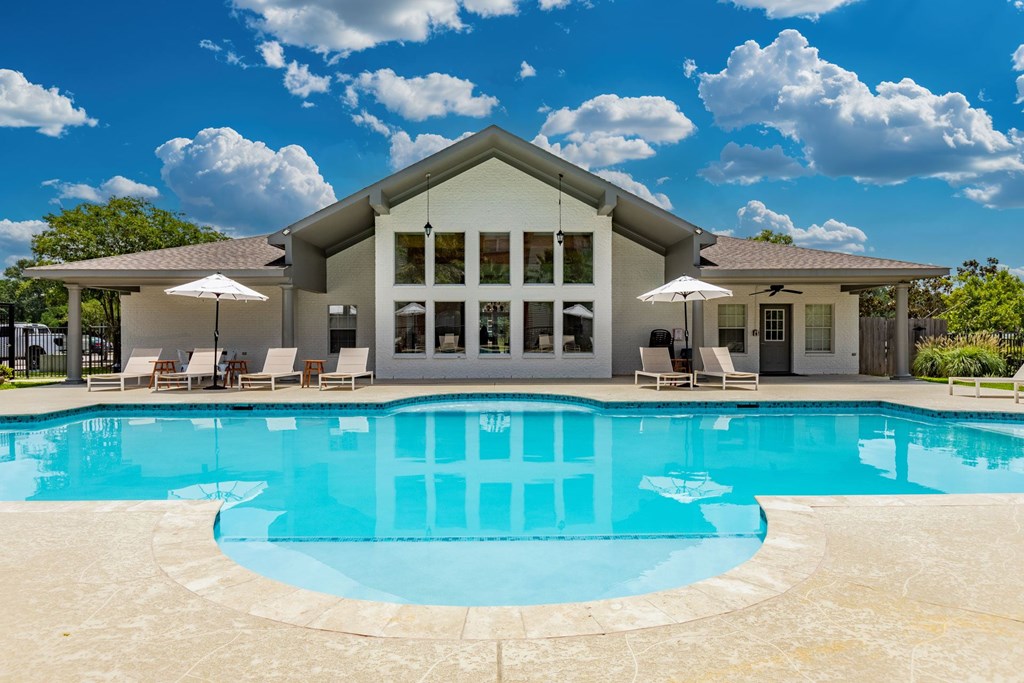 A large house with a pool in front.