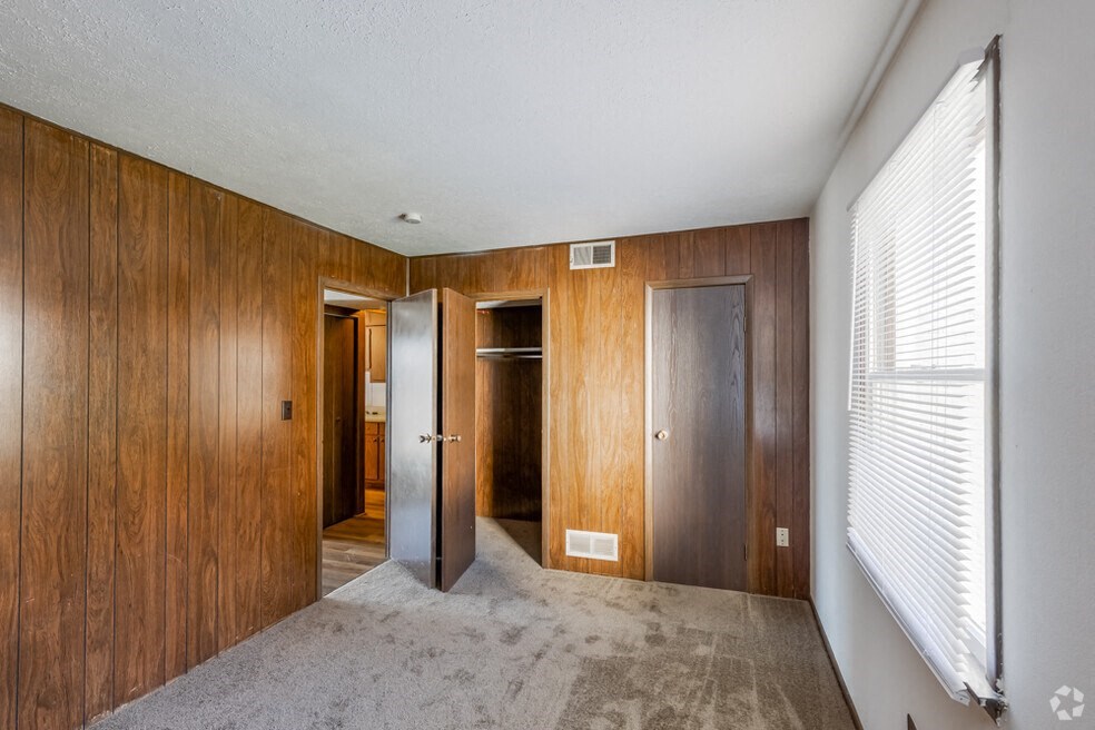 Bedroom with wood panel walls and carpet
