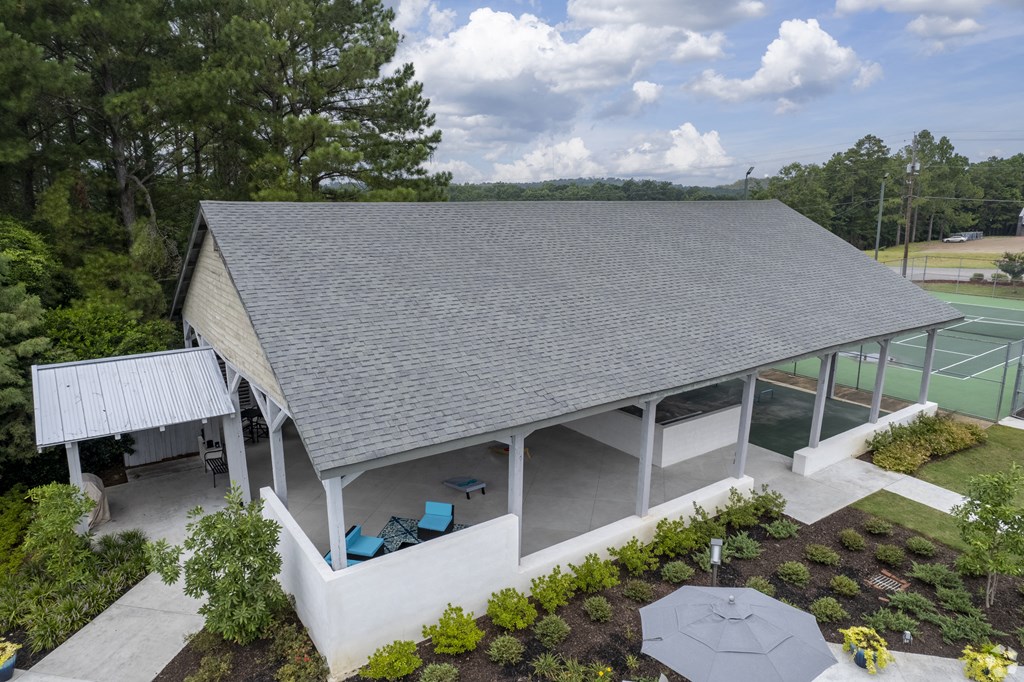 arial view of a building with a tennis court in the background
