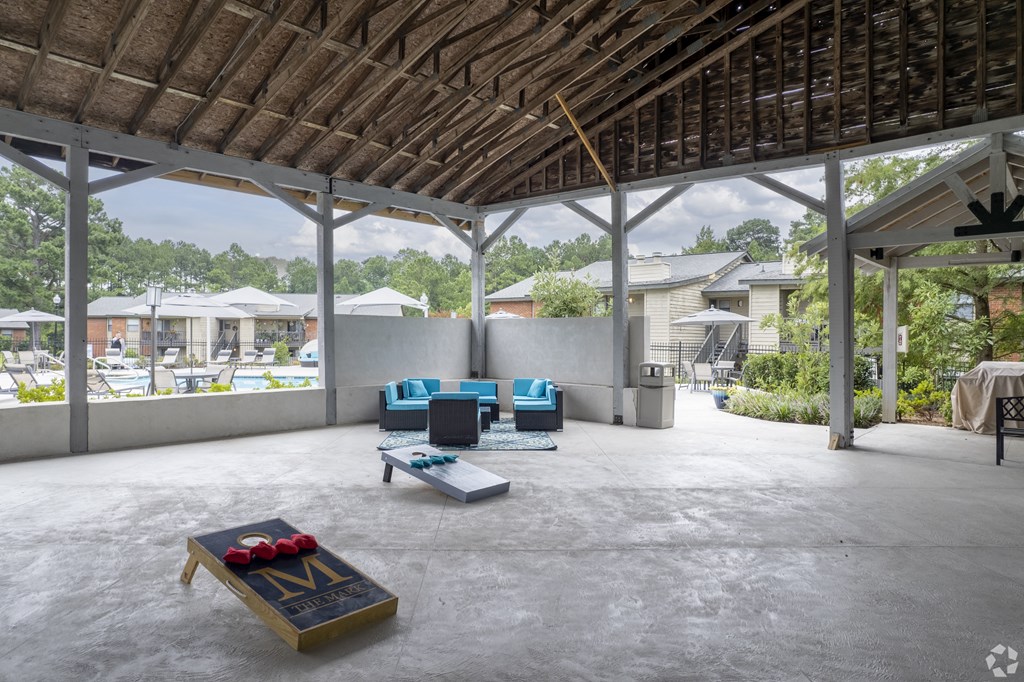 a large patio with furniture and a pool in the background