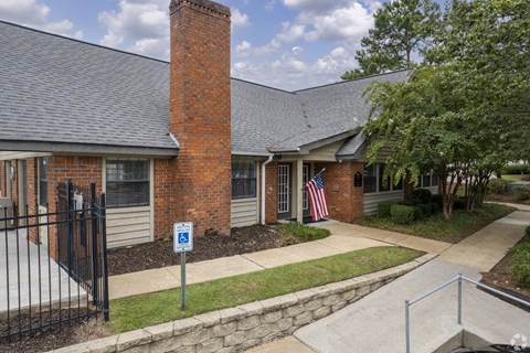 a building with a brick chimney and a flag in front of it
