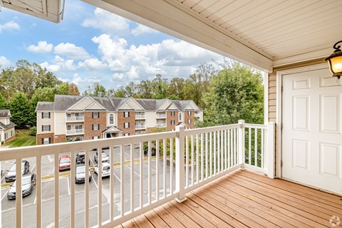 A balcony with a white railing and a white door.