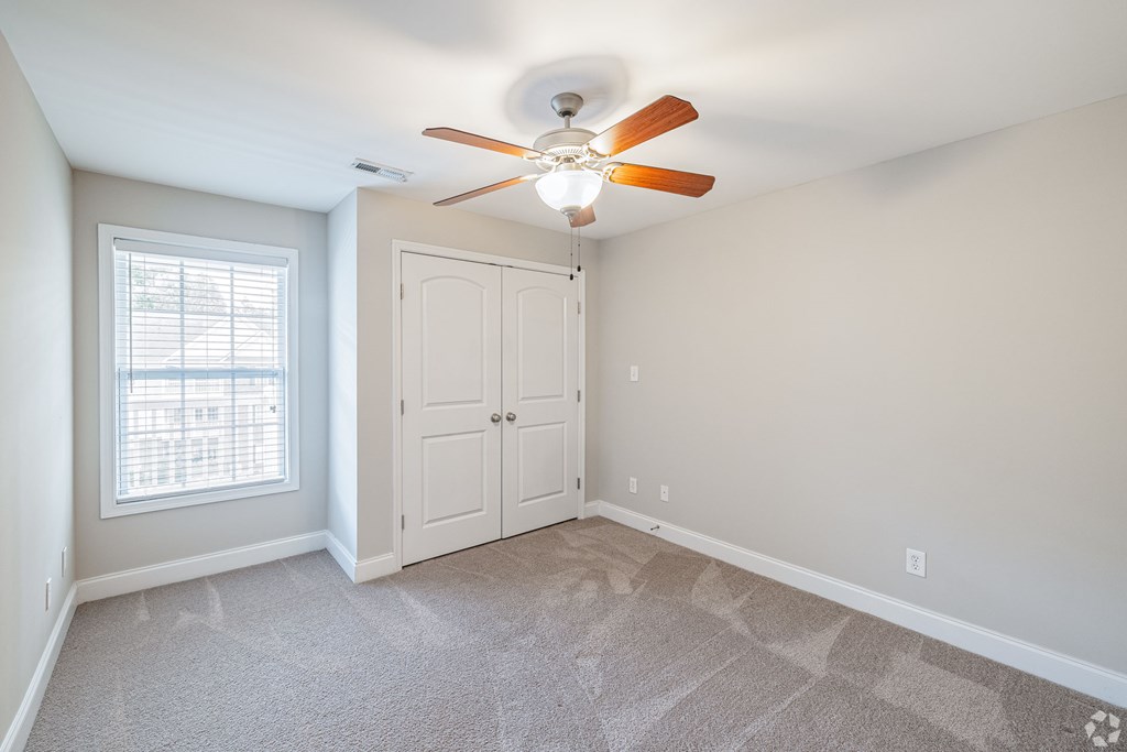A room with a ceiling fan and a window.