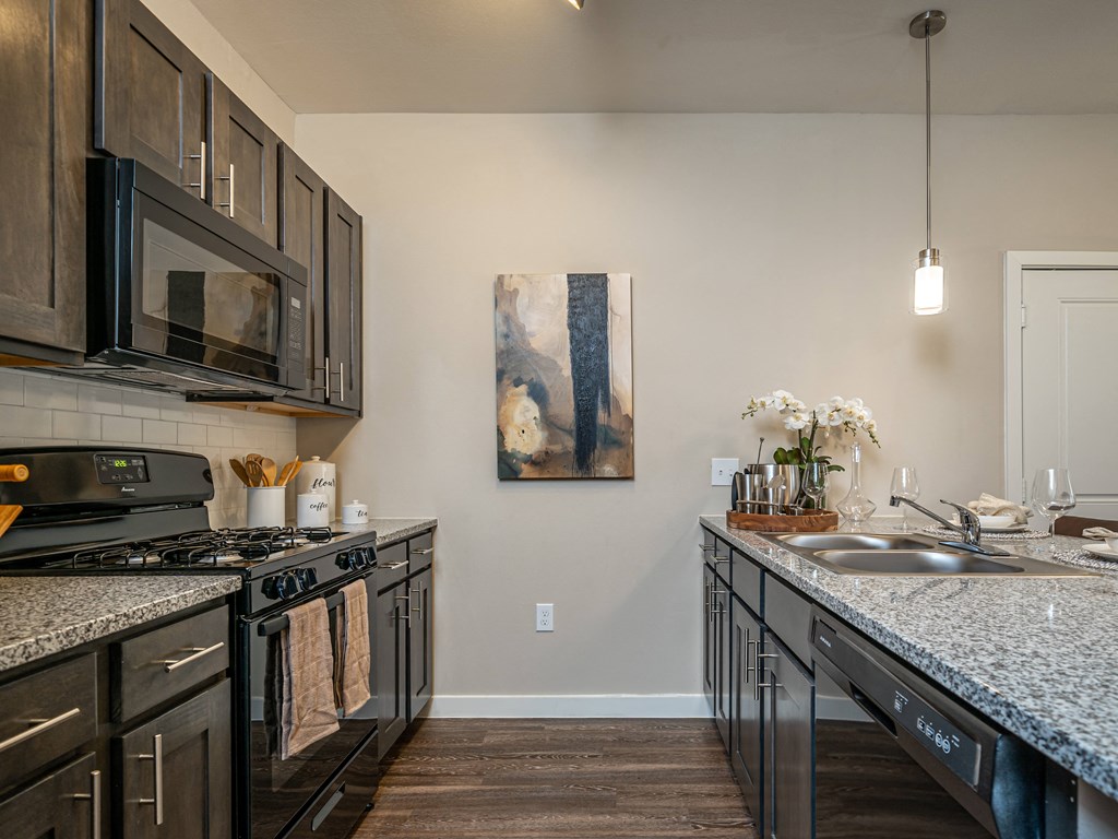 private kitchen with granite countertops and stainless steel appliances and a sink