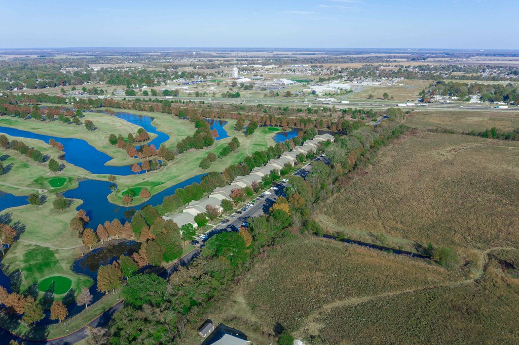 an aerial view of a golf course with a river in the background