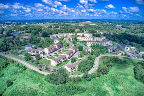 A bird's eye view of a residential area with multiple buildings and greenery.