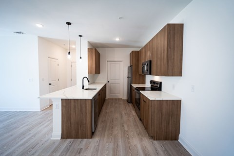 A modern kitchen with wooden cabinets and a white countertop.