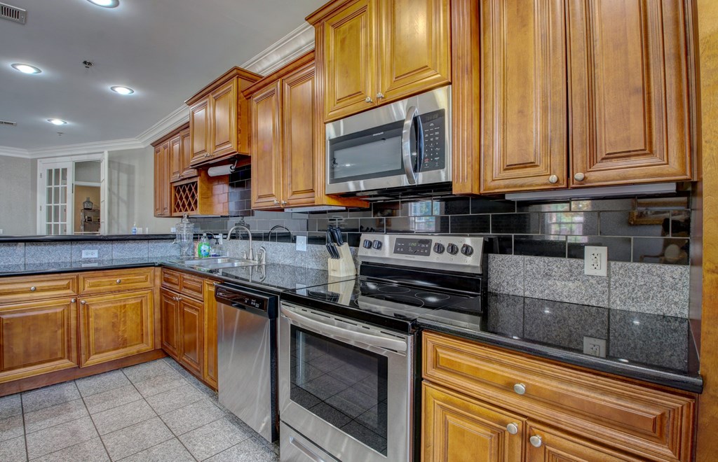 A kitchen with wooden cabinets and a black countertop.
