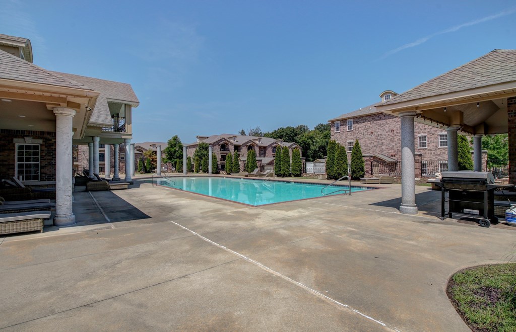 A swimming pool surrounded by houses and trees.