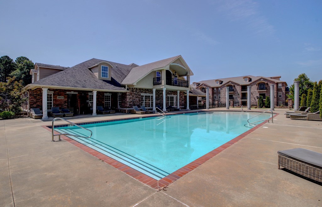 A large swimming pool in front of a house.