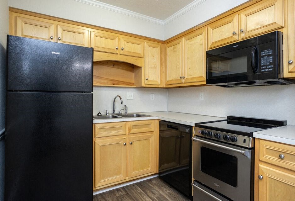 a kitchen with black appliances and wooden cabinets
