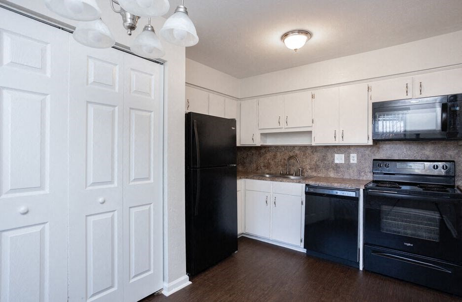 a kitchen with black appliances and white cabinets