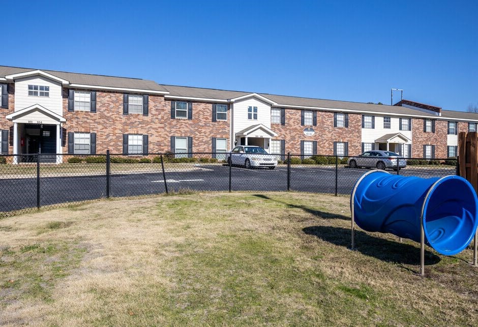 a blue barrel in front of a brick building