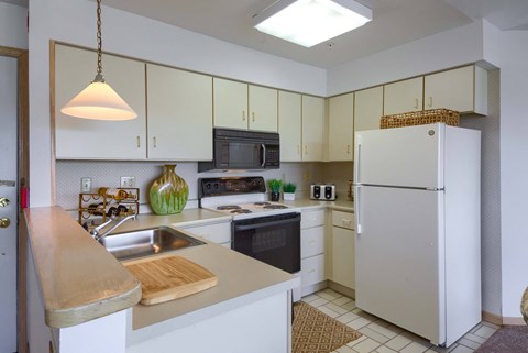 a kitchen with white cabinets and a sink and a refrigerator