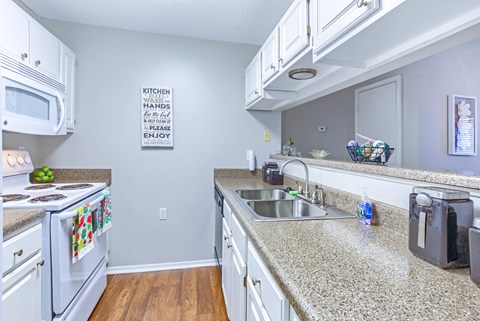 a kitchen with granite counter tops and white appliances