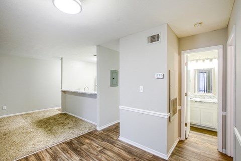 a renovated living room with white walls and wood flooring