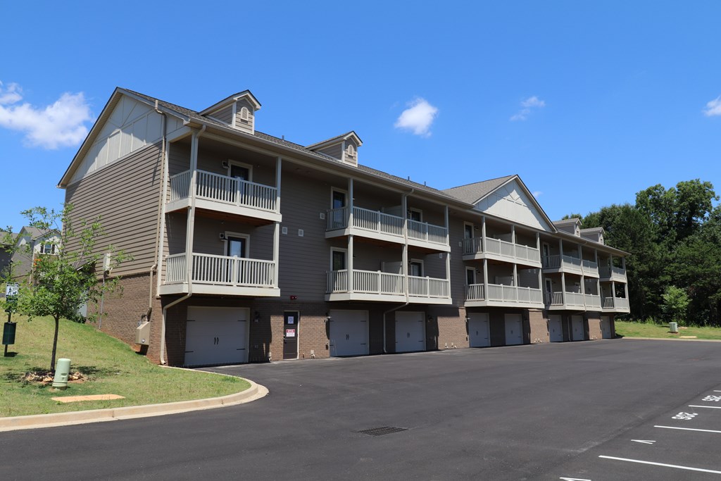 Apartment building with a parking lot in front.