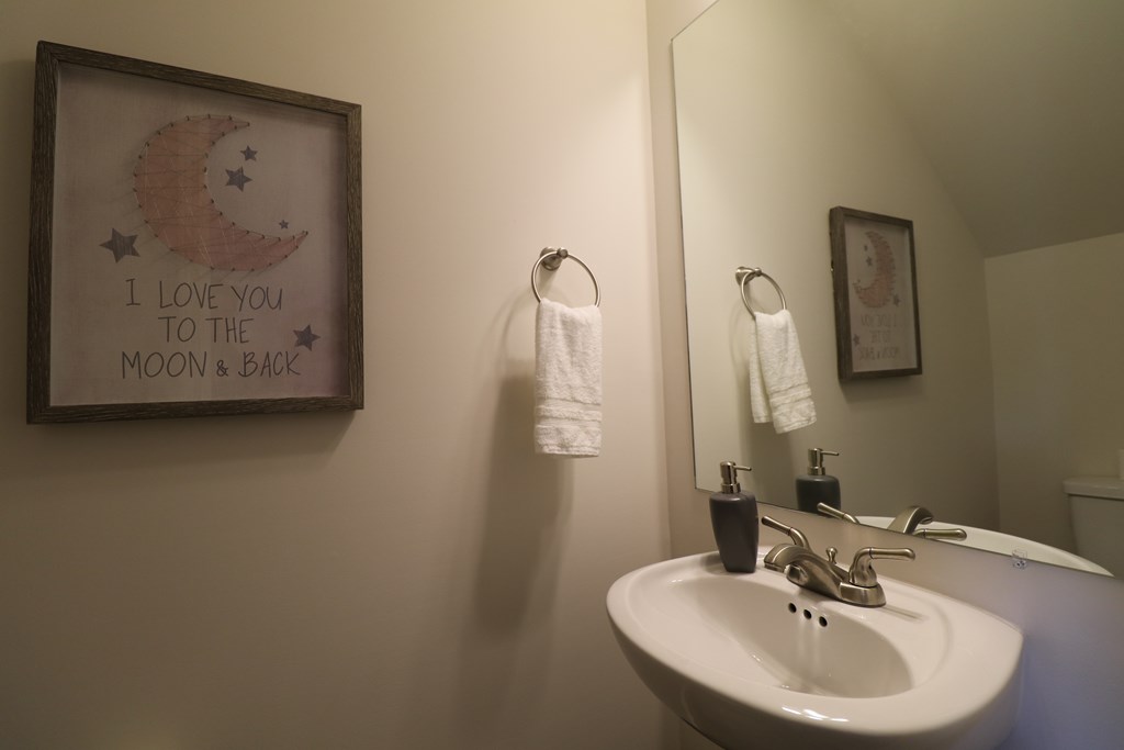A bathroom with a framed picture that says "I love you to the moon and back".