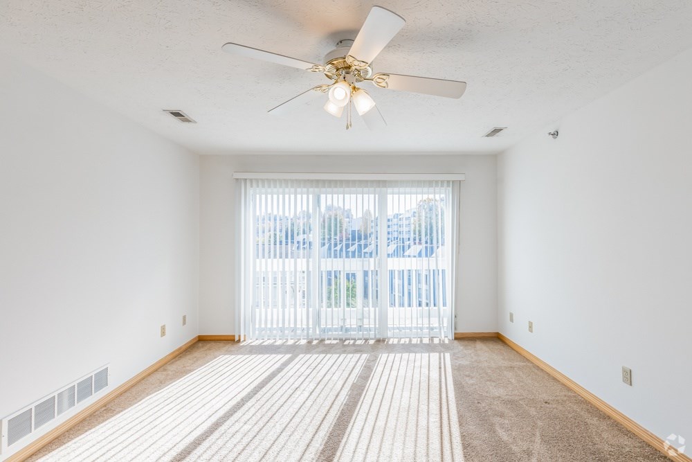 A room with a ceiling fan and a carpeted floor.