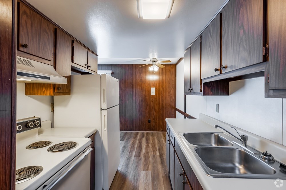 A kitchen with a stove top oven and a refrigerator.