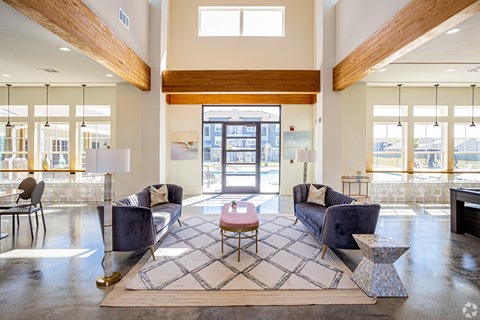 a living room with couches and a coffee table in front of a glass door