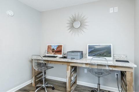 A white desk with a laptop and a printer on it.