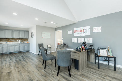 A room with a desk and chairs with a sign that says Latitude 30.