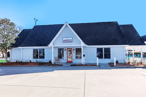 A small white building with a black roof and a sign that reads "LEISURE SPICES".