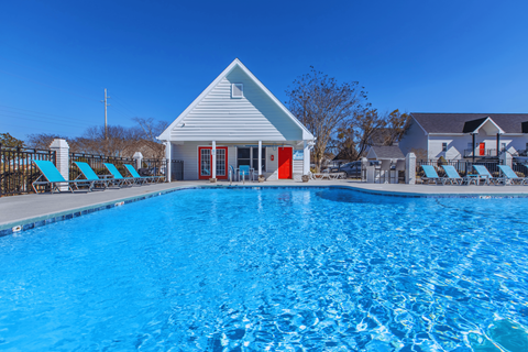 A pool with a house in the background.